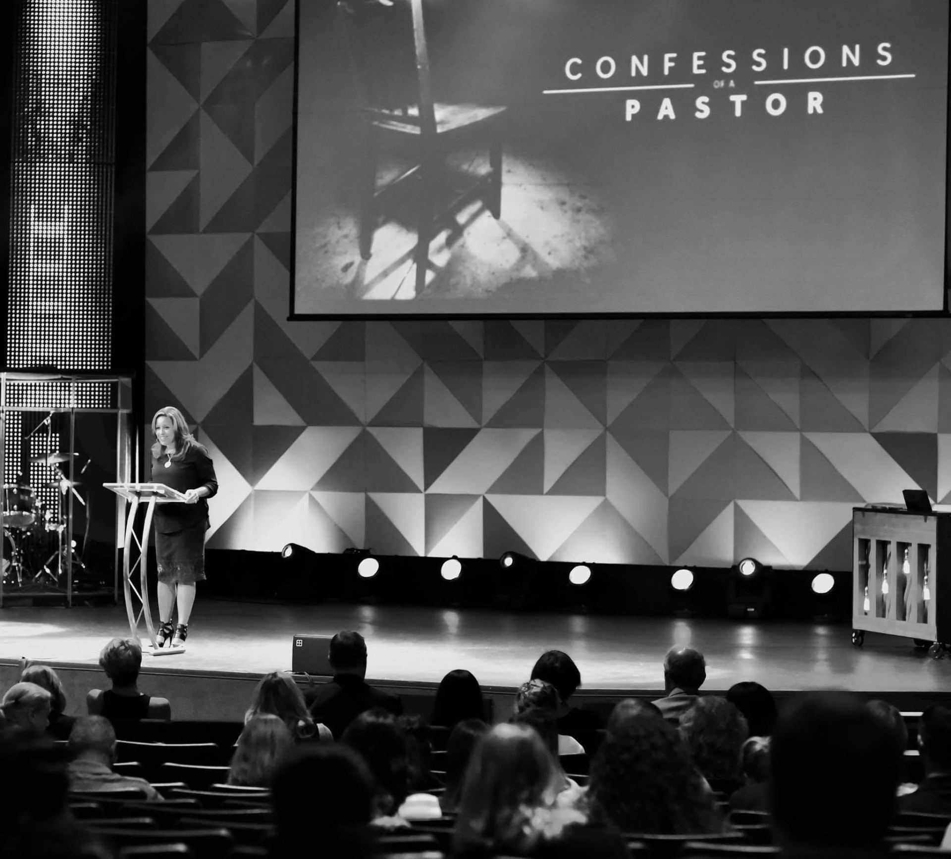 Roz Humphreys speaking on stage at a podium in front of a seated audience